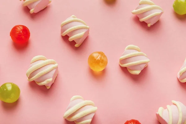 Крупный план зефира и красочных сладостей на розовом фоне — стоковое фото