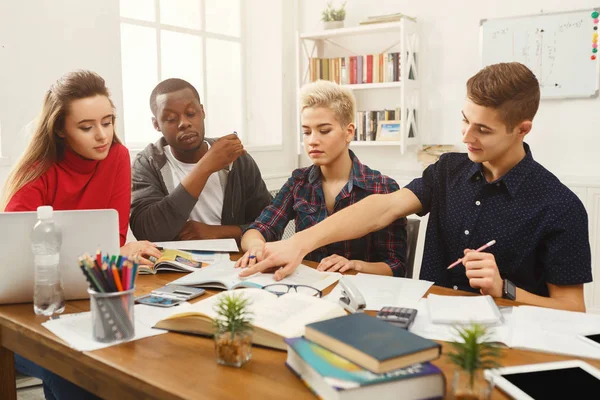 Grupo de estudantes diversos que estudam à mesa de madeira — Fotografia de Stock