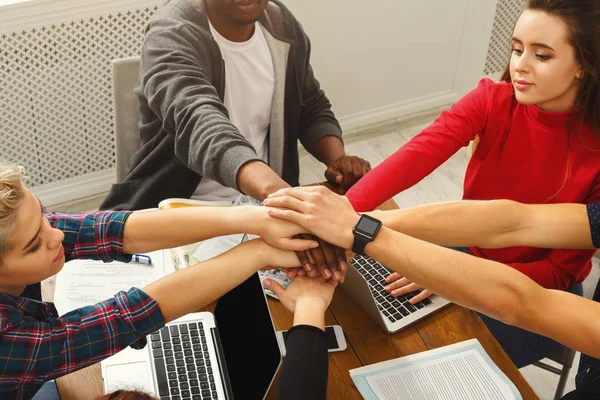 Gente de negocios en la mesa de trabajo poniendo manos juntas — Foto de Stock