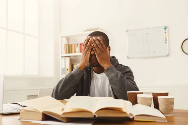 Negro estudiante masculino estudiando en la mesa llena de libros —  Fotos de Stock