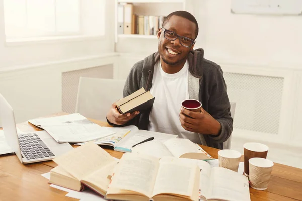Feliz estudiante negro estudiando en la mesa llena de libros — Foto de Stock