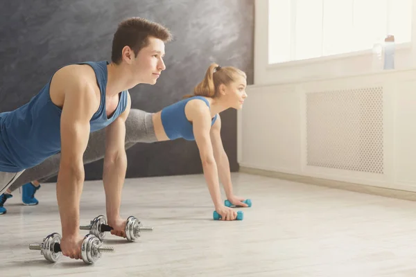 Couple making plank or push ups exercise indoors — Stock Photo, Image