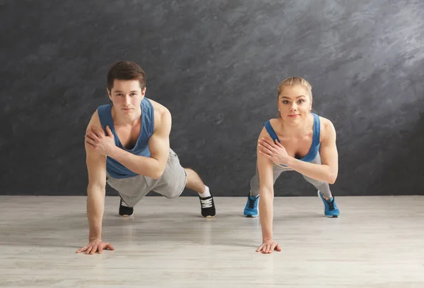 Pareja haciendo tablón o flexiones de ejercicio en interiores — Foto de Stock