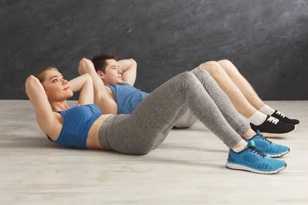 Fitness casal deitado fazendo crunches — Fotografia de Stock