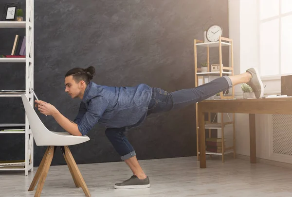 Hombre flexible practicando yoga en el lugar de trabajo —  Fotos de Stock