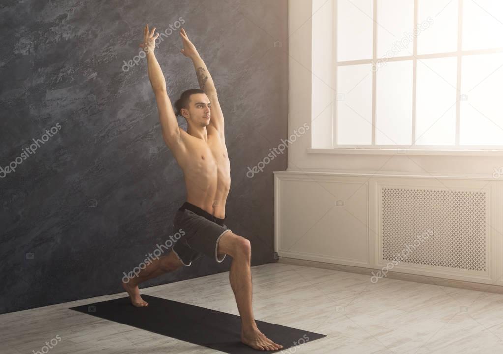 Man stretching hands and legs at gym