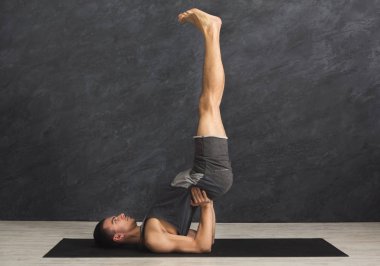 Omuz stand yapmak yoga sınıfındaki genç adam