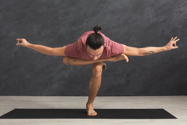 Junger flexibler Mann praktiziert Yoga im Fitnessstudio — Stockfoto