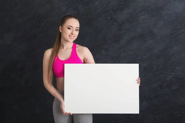 Joven mujer deportiva con papel blanco en blanco — Foto de Stock