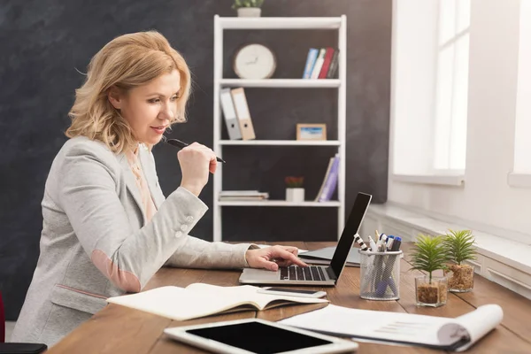 Koncentrerad affärskvinna som arbetar på laptop på kontoret — Stockfoto