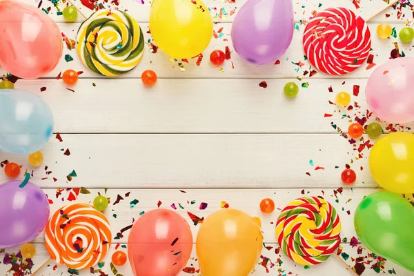 Colorful balloons on white rustic wood, birthday background, top view — Stock Photo, Image