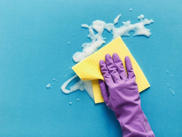 Main dans le gant laver la surface en verre avec chiffon et mousse de nettoyage — Photo