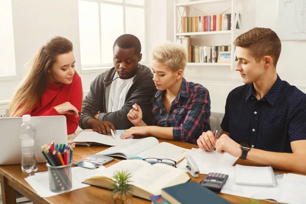 Grupo de estudiantes diversos que estudian en la mesa de madera — Foto de Stock