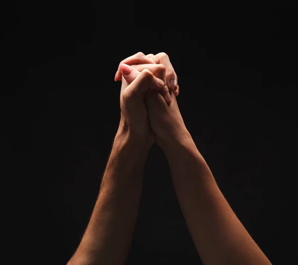 Руки мужчины и женщины, скрепленные вместе на черном фоне — стоковое фото