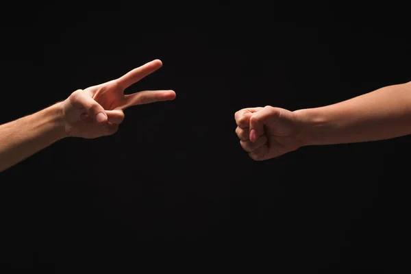 Dos manos jugando tijeras de papel de roca sobre fondo negro —  Fotos de Stock