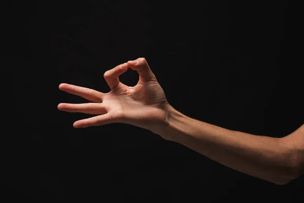 Mannenhand oppakken van iets, knipsel op zwart — Stockfoto