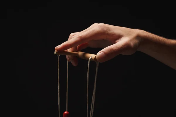 Manipulators hand with marionette string isolated on black — Stock Photo, Image