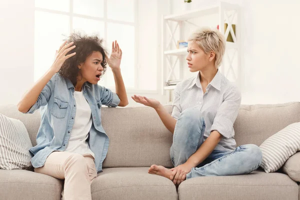 Dos amigas sentadas en un sofá discutiendo —  Fotos de Stock