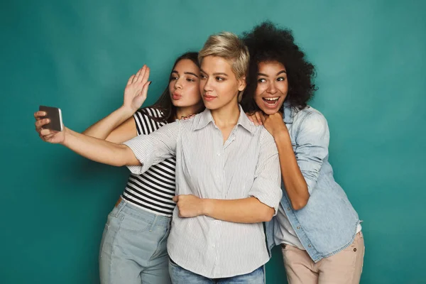 Três mulheres felizes tirando selfie no estúdio — Fotografia de Stock