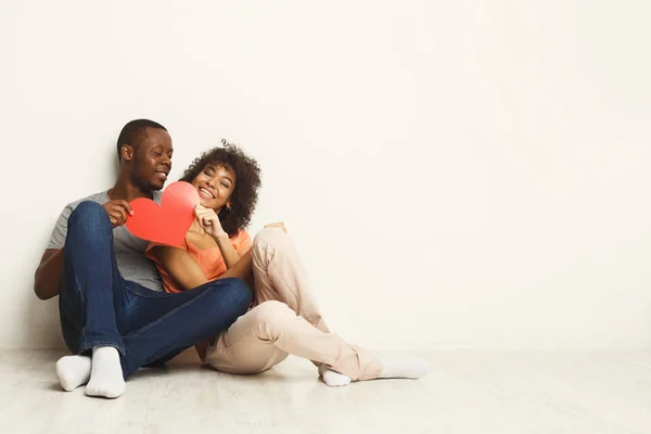 Lyckliga afro-amerikanska paret håller papper hjärta — Stockfoto
