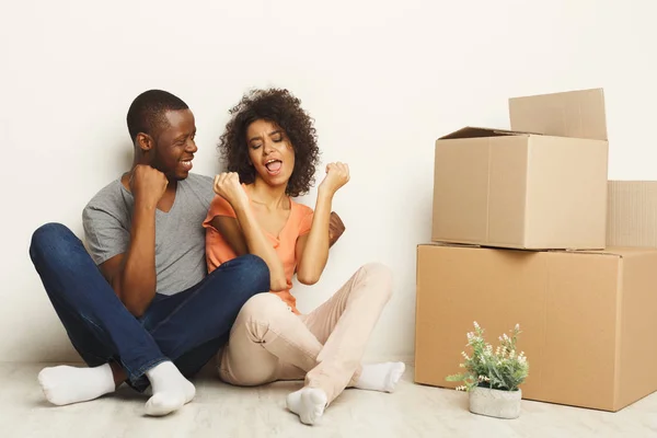 Casal preto sentado no chão no novo apartamento — Fotografia de Stock