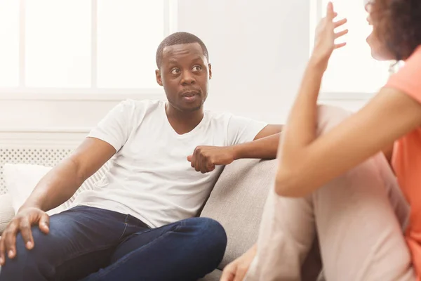 Emozionale coppia nera parlando sul divano a casa — Foto Stock