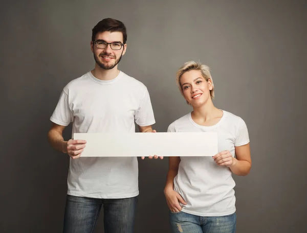 年轻夫妇拿着空白的白色横幅 — 图库照片