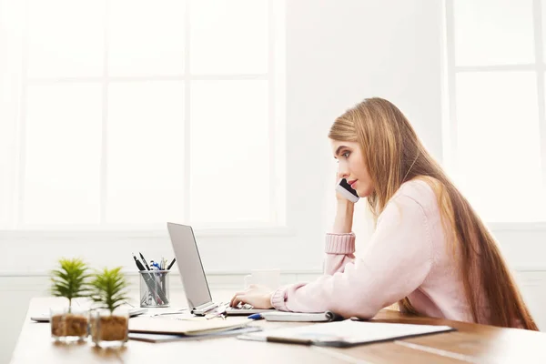 Серьёзная деловая женщина на работе разговаривает по телефону — стоковое фото