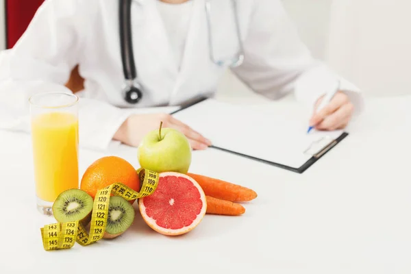Nutritionist desk with fruit and measuring tape — Stock Photo, Image