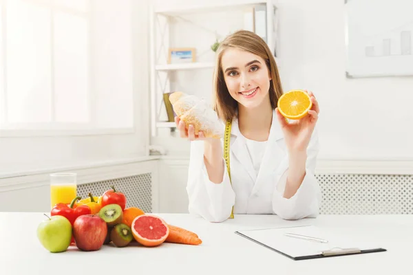 Dietitian nutritionist with bun and orange — Stock Photo, Image