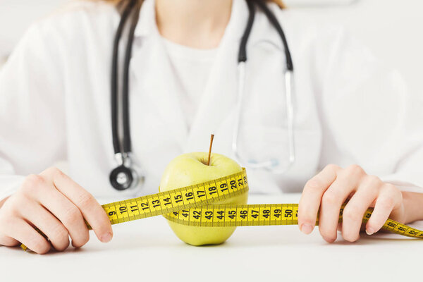 The apple is rewound by measuring tape by dietician