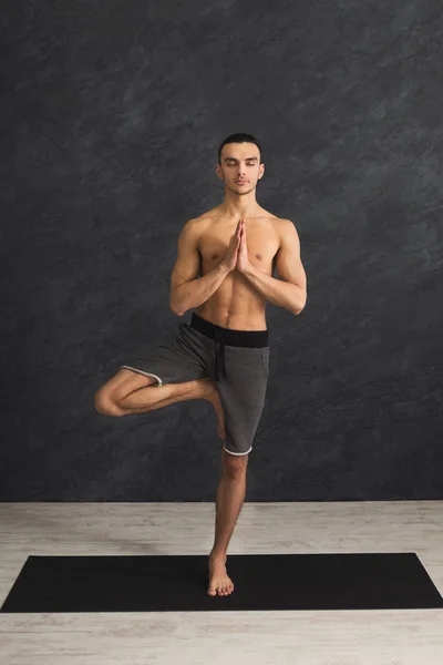 Joven entrenando yoga en pose de árbol — Foto de Stock