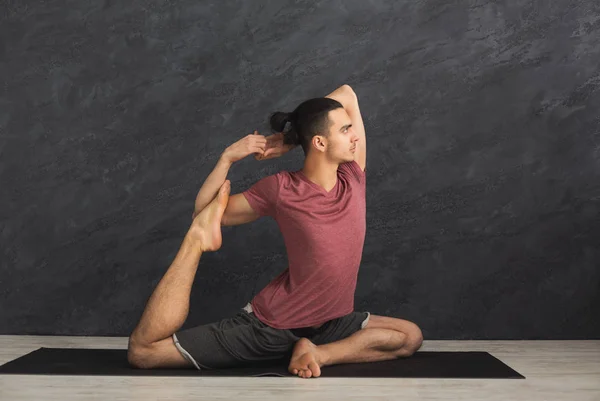 Молодий гнучкий чоловік практикує йогу в спортзалі — стокове фото