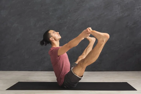 Jeune homme pratiquant le yoga avec tapis de gymnastique — Photo