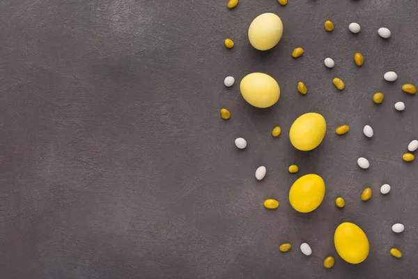 Paskalya arka plan. Renkli yumurta ve tatlılar gri taş yüzeyi — Stok fotoğraf