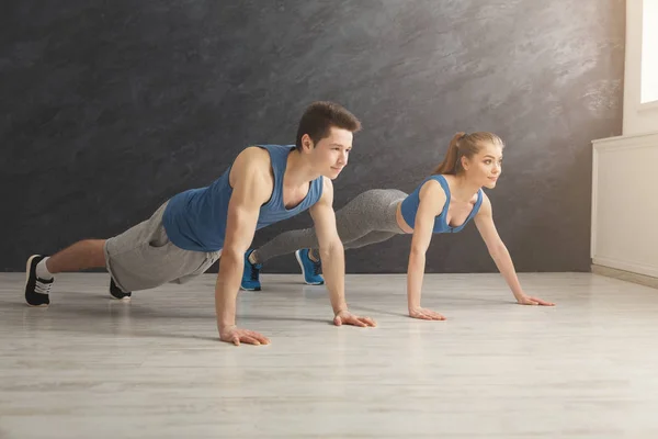 Couple faisant planche ou push ups exercice à l'intérieur — Photo