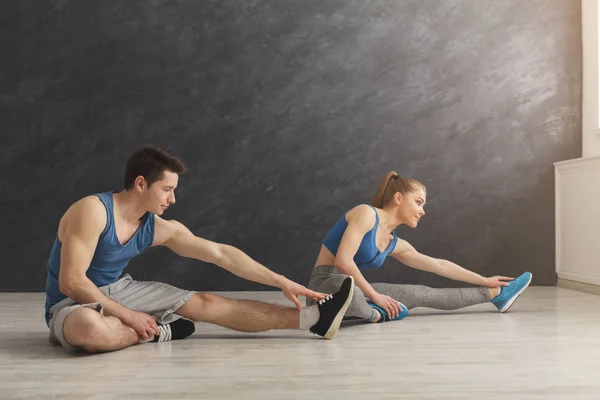 Casal de fitness no treinamento de alongamento dentro de casa — Fotografia de Stock