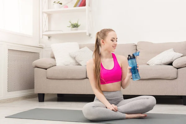 Fitness vrouw drinkwater thuis — Stockfoto