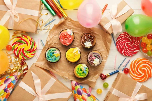 Sortimento de cupcakes saborosos e muitas decorações de festa de aniversário — Fotografia de Stock