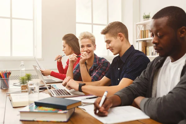 Grupp av olika studenter som studerar vid träbord — Stockfoto