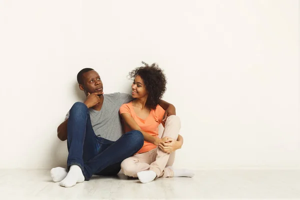 Afro-para, przytulanie, siedząc na podłodze — Zdjęcie stockowe
