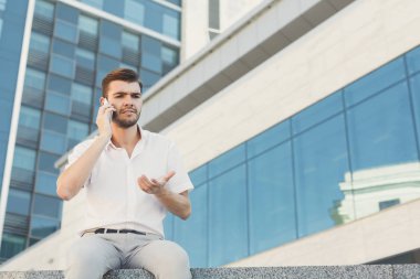 Şaşkın işadamı bir telefon görüşmesi açık havada yapma