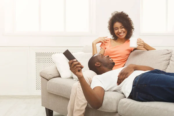 Feliz casal afro-americano assistindo TV em casa — Fotografia de Stock