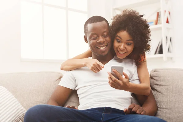 Casal preto fazendo usando smartphone em casa — Fotografia de Stock