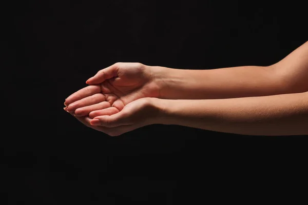 Femme gardant les mains en forme de coupe, découpe sur noir — Photo