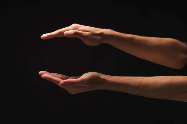 Αρσενικό χέρια μέτρηση κάτι σε μαύρο φόντο — Φωτογραφία Αρχείου