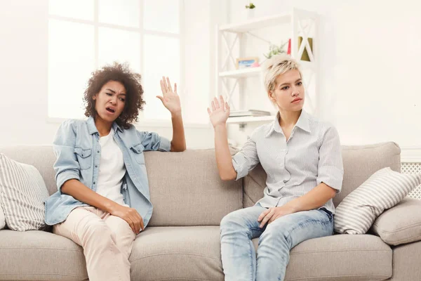 Дві подружки сидять на дивані і сперечаються — стокове фото