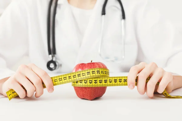 A maçã é enrolado por fita métrica pelo nutricionista — Fotografia de Stock