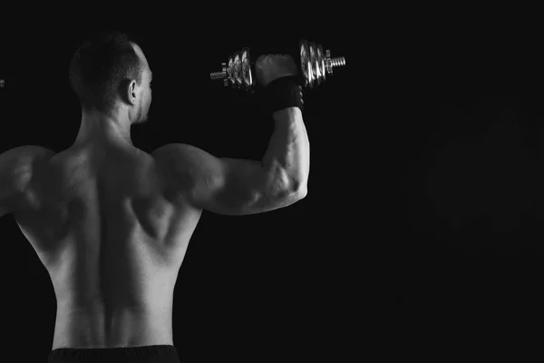 强壮的男子与哑铃表明裸肌肉身体 — 图库照片