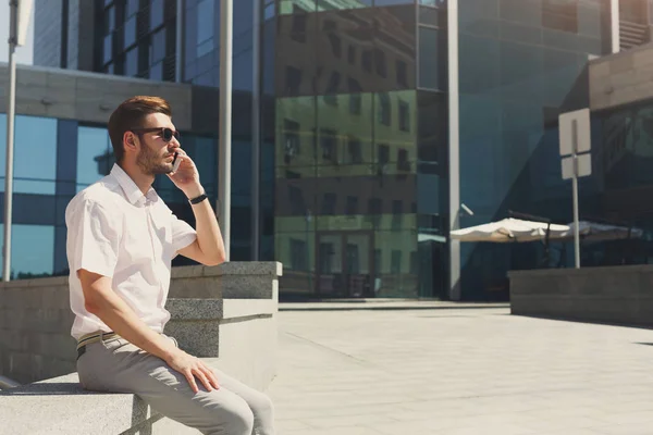 Joven confiado haciendo una llamada al aire libre — Foto de Stock